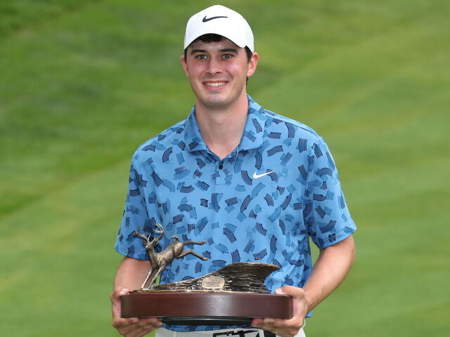 SILVIS, IL - JULiY 07: PGA golfer Davis Thompson poses with the trophy after winning the John Deere Classic on July 7,2024, at the TPC Deere Run in Silvis, Illinois.