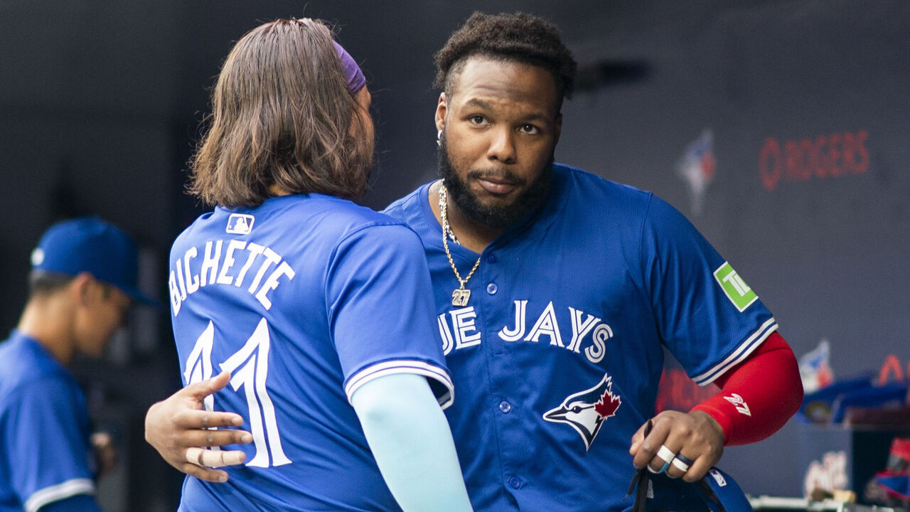 TORONTO, ON - JULY 2: Vladimir Guerrero Jr. #27 and Bo Bichette #11 of the Toronto Blue Jays hug in the dugout before playing the Houston Astros in their MLB game at the Rogers Centre on July 2, 2024 in Toronto, Ontario, Canada.