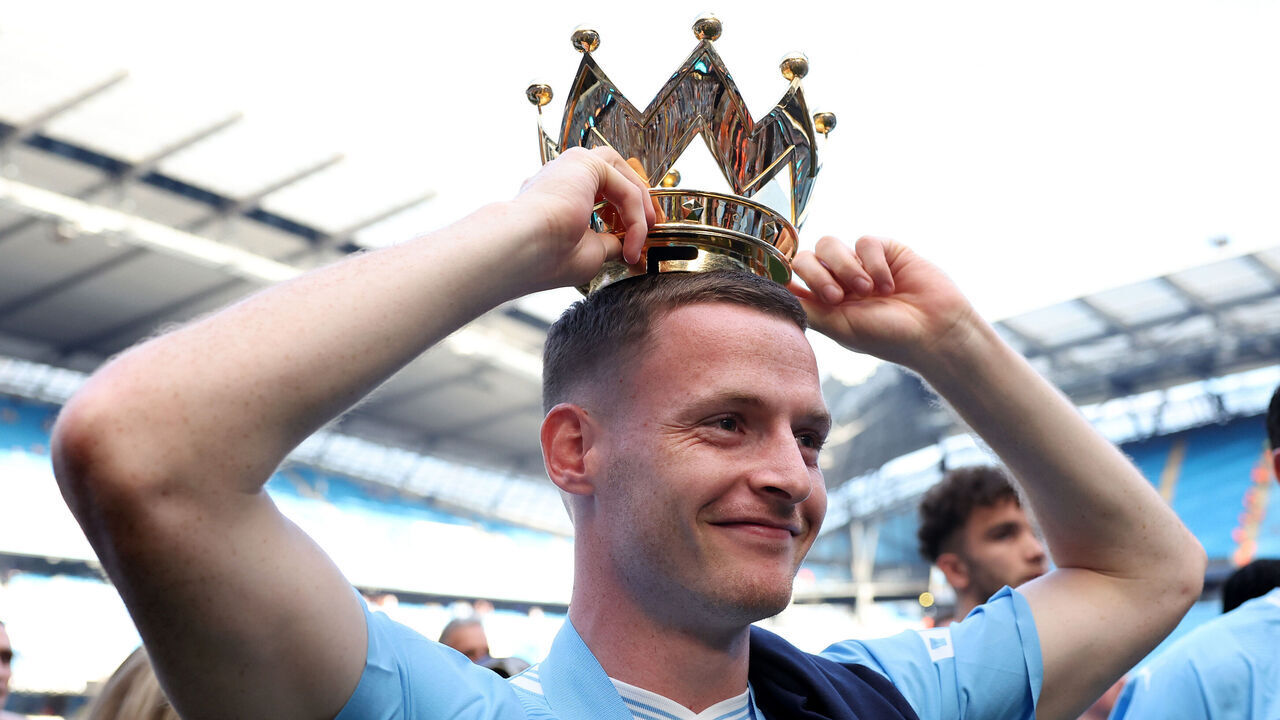 MANCHESTER, ENGLAND - MAY 19: Sergio Gomez of Manchester City poses with the Premier League trophy crown after the Premier League match between Manchester City and West Ham United at Etihad Stadium on May 19, 2024 in Manchester, England.