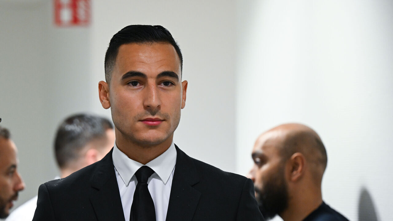19 June 2024, Rhineland-Palatinate, Mainz: Professional footballer Anwar El Ghazi (r) and his lawyer Alexander Bergweiler (l) wait in the corridor of the labor court for the hearing to begin. El Ghazi had been dismissed without notice by Bundesliga club 1. FSV Mainz 05 due to repeated pro-Palestinian Instagram posts. A conciliation hearing before the labor court failed in January. Photo: Arne Dedert/dpa