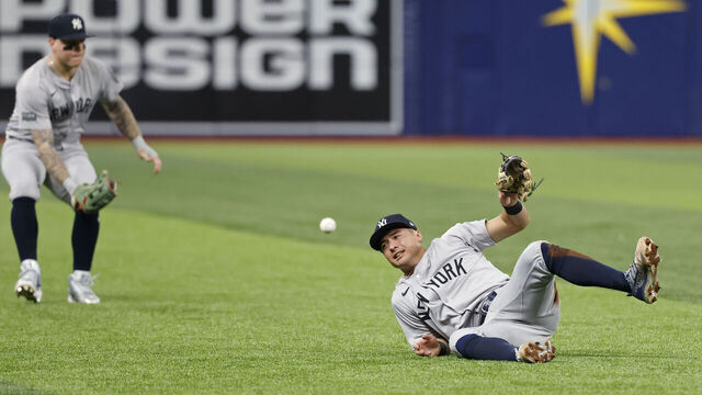 ST. PETERSBURG, FL - JULY 10: New York Yankees shortstop Anthony Volpe (11) falls down trying to catch a pop up while backed up by outfielder Alex Verdugo (24) during an MLB game against the Tampa Bay Rays on July 10, 2024 at Tropicana Field in St. Petersburg, Florida.