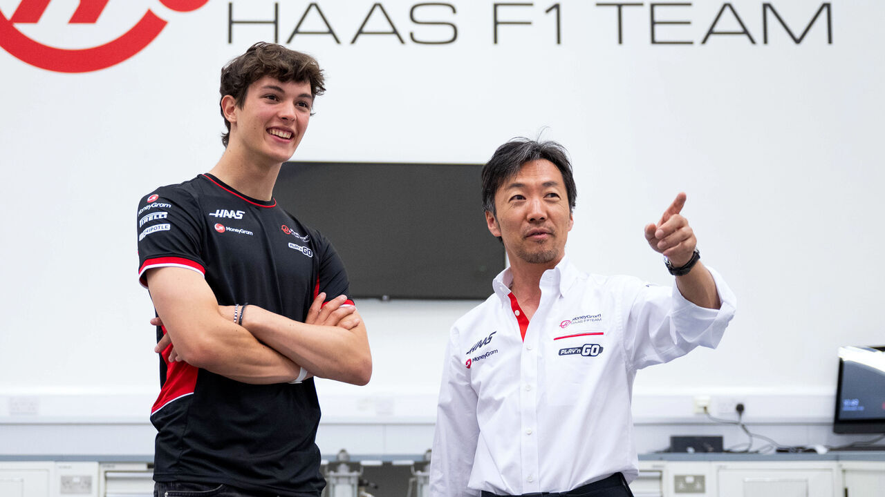 BANBURY, ENGLAND - JULY 03: Oliver Bearman of Great Britain and Haas F1 and Haas F1 Team Principal Ayao Komatsu talk in the factory as he signs a deal for the 2025 season with Haas F1 during previews ahead of the F1 Grand Prix of Great Britain at Haas F1 Factory on July 03, 2024 in Banbury, England.