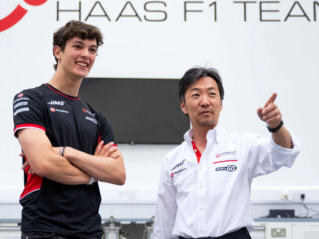 BANBURY, ENGLAND - JULY 03: Oliver Bearman of Great Britain and Haas F1 and Haas F1 Team Principal Ayao Komatsu talk in the factory as he signs a deal for the 2025 season with Haas F1 during previews ahead of the F1 Grand Prix of Great Britain at Haas F1 Factory on July 03, 2024 in Banbury, England.