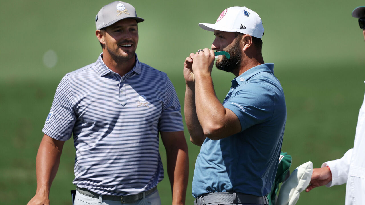 AUGUSTA, GEORGIA - APRIL 08: Bryson DeChambeau of the United States and Jon Rahm of Spain use glasses to view the eclipse during a practice round prior to the 2024 Masters Tournament at Augusta National Golf Club on April 08, 2024 in Augusta, Georgia.