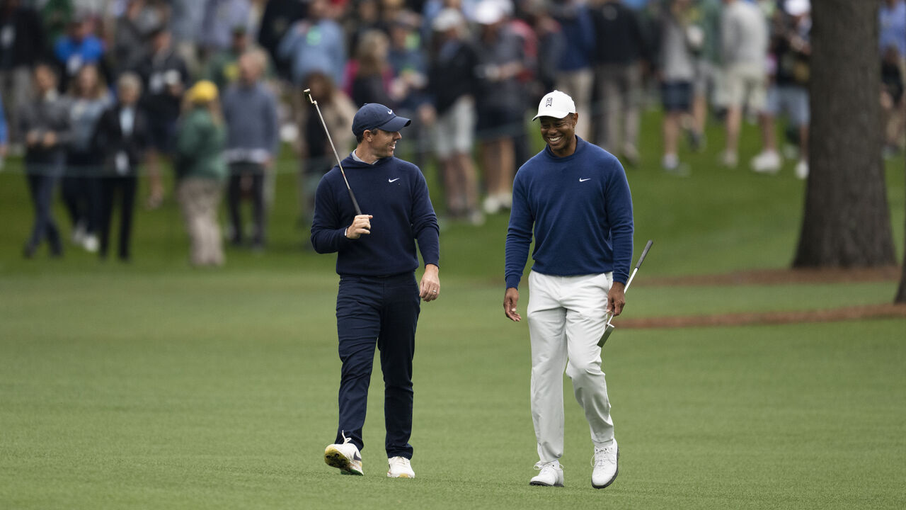 Rory McIlroy of Northern Ireland and Masters champion Tiger Woods of the United States walk down the No. 11 fairway during practice round 1 at Augusta National Golf Club, Monday, April 3, 2023.