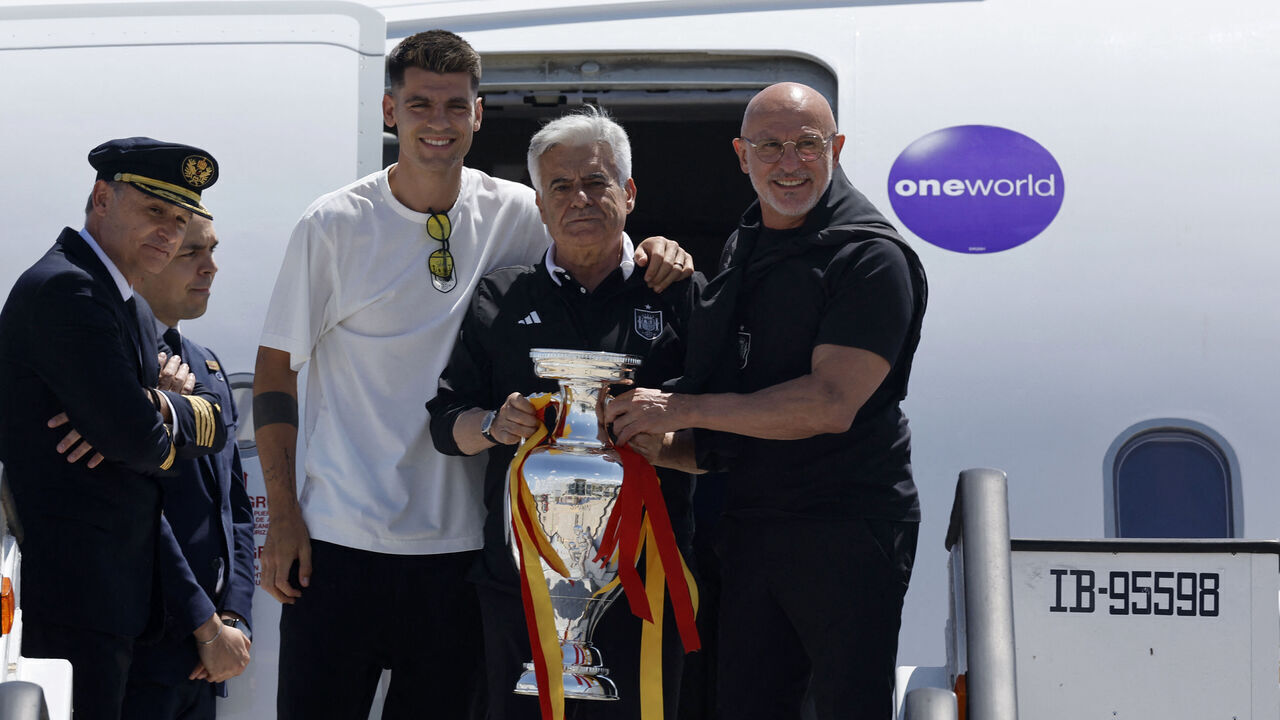 Spain's forward #07 Alvaro Morata (L) Spanish football federation president Pedro Rocha (C) and Spain's head coach Luis de la Fuente (R) pose with the UEFA Euro 2024 trophy while arriving at Adolfo Suárez MadridBarajas Airport in Madrid on July 15, 2024, the day after winning the final against England.
