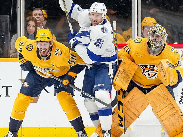 NASHVILLE, TENNESSEE - DECEMBER 7: Steven Stamkos #91 of the Tampa Bay Lightning battles in front of the net against Roman Josi #59 and Juuse Saros #74 of the Nashville Predators during an NHL game at Bridgestone Arena on December 7, 2023 in Nashville, Tennessee.