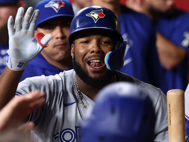 PHOENIX, ARIZONA - JULY 12: Vladimir Guerrero Jr. #27 of the Toronto Blue Jays celebrates with teammates after hitting a sacrifice fly during the eighth inning against the Arizona Diamondbacks at Chase Field on July 12, 2024 in Phoenix, Arizona.
