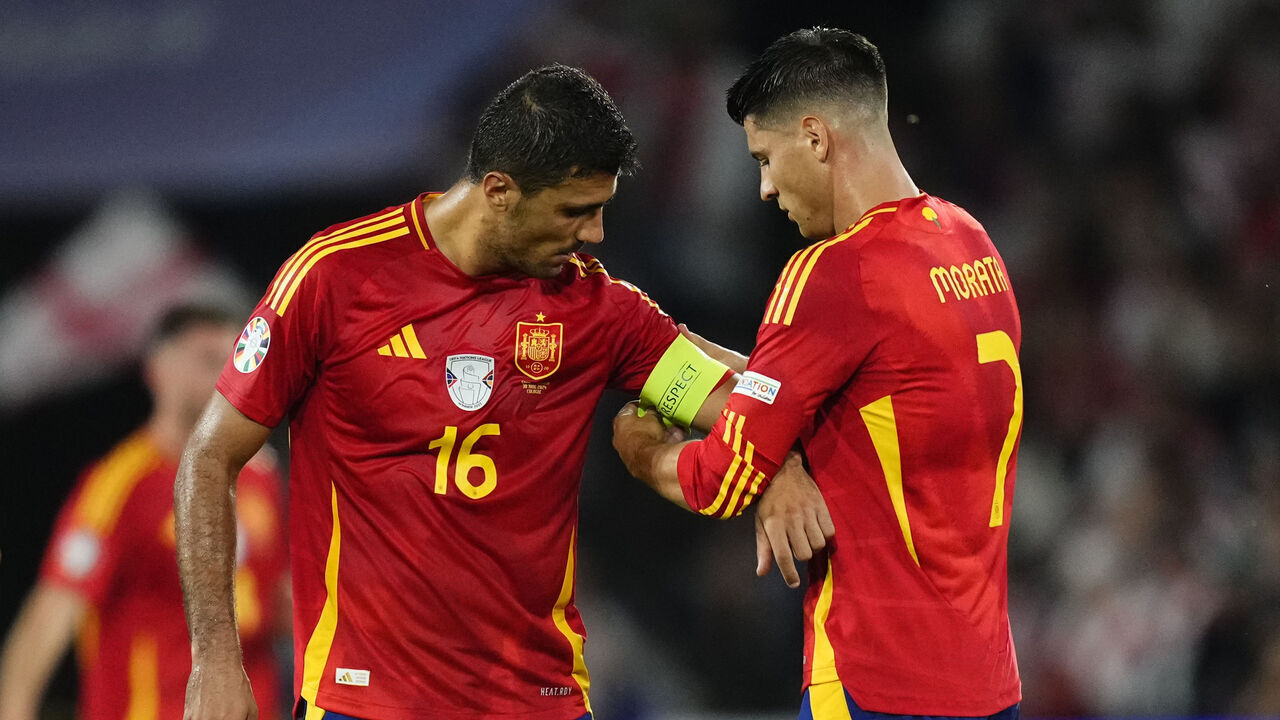 Alvaro Morata centre-forward of Spain and Atletico de Madrid gives the captain's armband to Rodrigo Hernandez defensive midfield of Spain and Manchester City during the UEFA EURO 2024 round of 16 match between Spain and Georgia at Cologne Stadium on June 30, 2024 in Cologne, Germany.