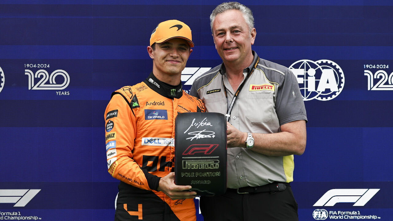 BUDAPEST, HUNGARY - JULY 20: Lando Norris of Great Britain and McLaren F1 Team receives the Pirelli Pole Position Award from Pirelli's Head of F1 & Car Racing Mario Isola in parc feme after qualifying ahead of the F1 Grand Prix of Hungary at Hungaroring on July 20, 2024 in Budapest, Hungary.