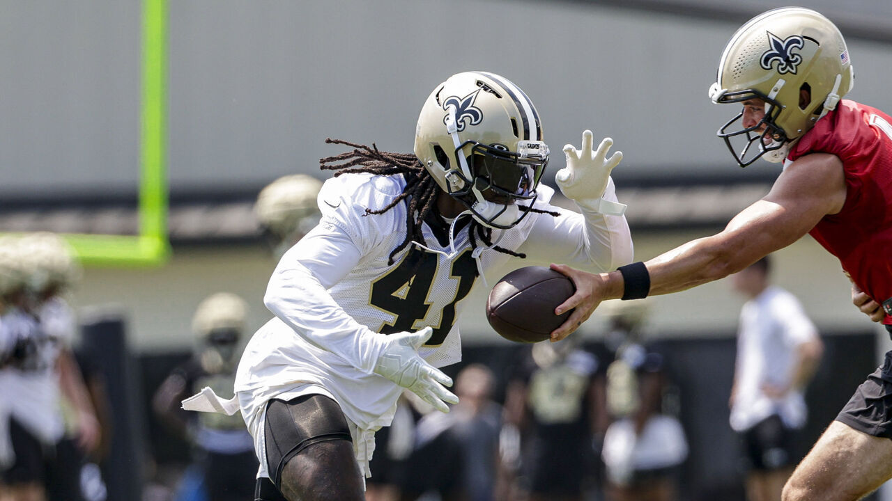 METAIRIE, LOUISIANA - JUNE 11: Alvin Kamara #41 of the New Orleans Saints takes a handoff from Derek Carr #4 during mandatory minicamp at the New Orleans Saints Practice Facility on June 11, 2024 in Metaire, Louisiana.