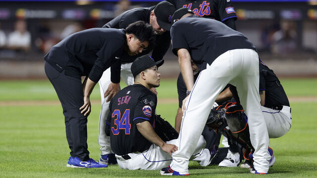 NEW YORK, NEW YORK - JULY 26: Kodai Senga #34 of the New York Mets sits on the field and is checked out by team staff after an injury during the sixth inning against the Atlanta Braves at Citi Field on July 26, 2024 in New York City.