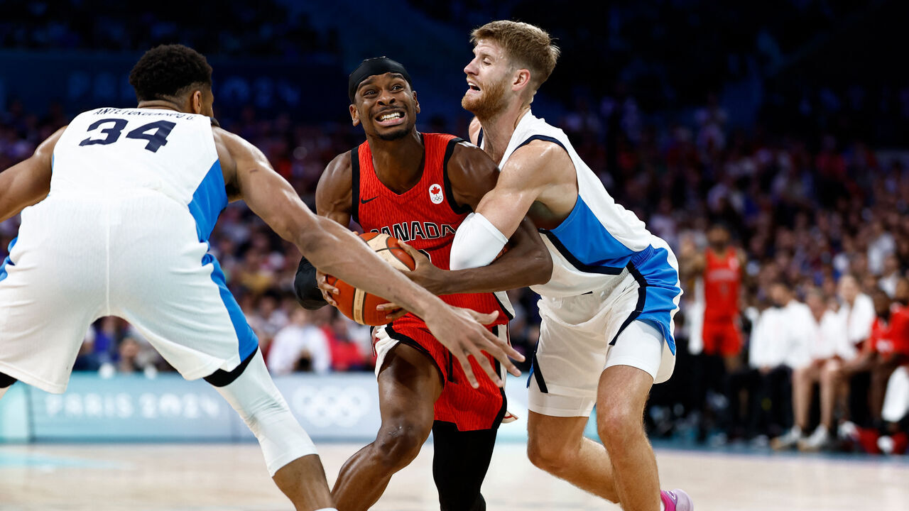 Canada's #02 Shai Gilgeous-Alexander (C) challenges Greece's #34 Giannis Antetokounmpo (L) and Greece's #0 Thomas Walkup in the men's preliminary round group A basketball match between Greece and Canada during the Paris 2024 Olympic Games at the Pierre-Mauroy stadium in Villeneuve-d'Ascq, northern France, on July 27, 2024.