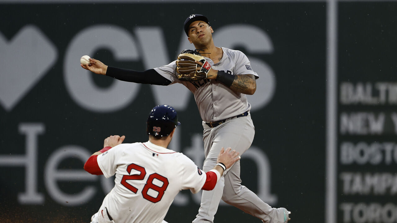 BOSTON, MA - JULY 28: Gleyber Torres #25 of the New York Yankees throws over Danny Jansen #28 of the Boston Red Sox but could not complete the double play during the third inning at Fenway Park on July 28, 2024 in Boston, Massachusetts.