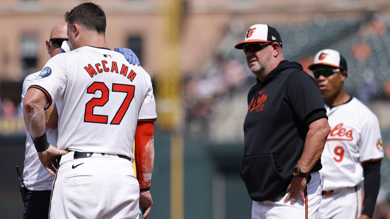 BALTIMORE, MD - JULY 29: Baltimore Orioles catcher James McCann (27) gets medical attention after being hit in the face with a pitch in the first inning during an MLB game against the Toronto Blue Jays on July 29, 2024 at Oriole Park at Camden Yards in Baltimore, Maryland.