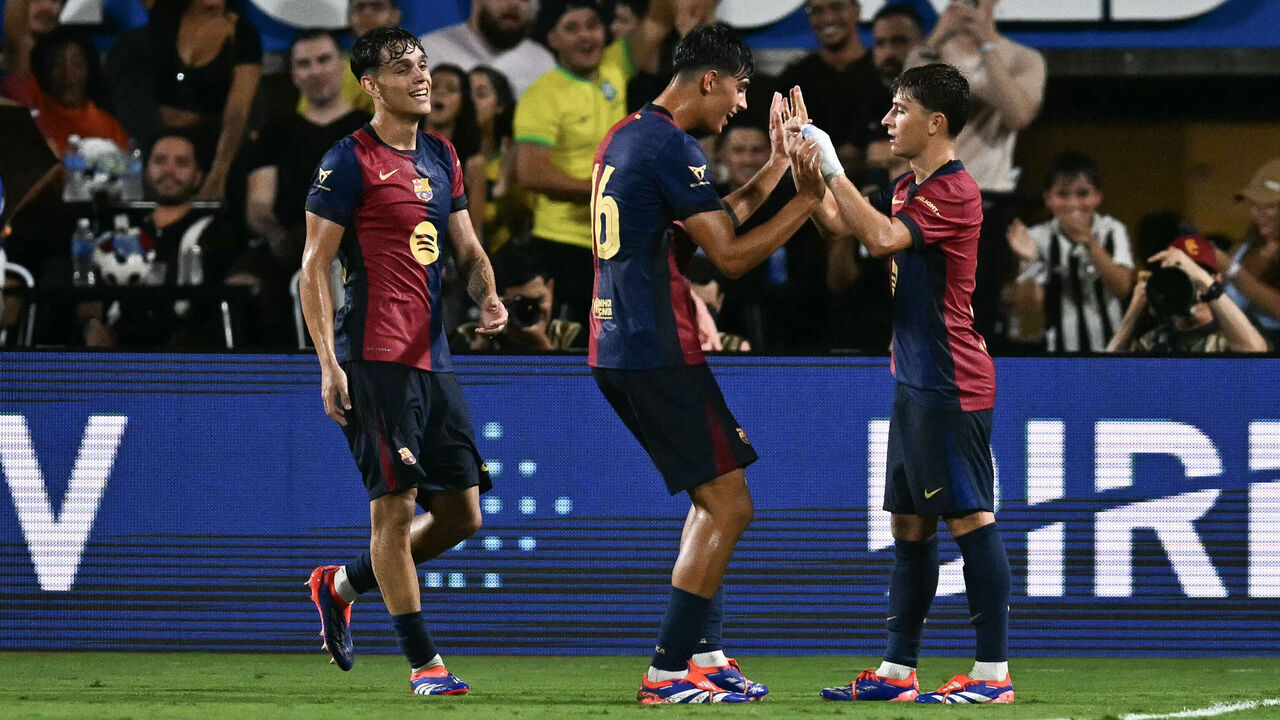 Barcelona's midfielder #6 Pablo Torre (R) celebrates with teammate #16 Marc Bernal (C) after Torre scored a goal during the 2024 FC Series pre-season friendly football match between FC Barcelona and Manchester City at Camping World Stadium in Orlando, Florida, on July 30, 2024.
