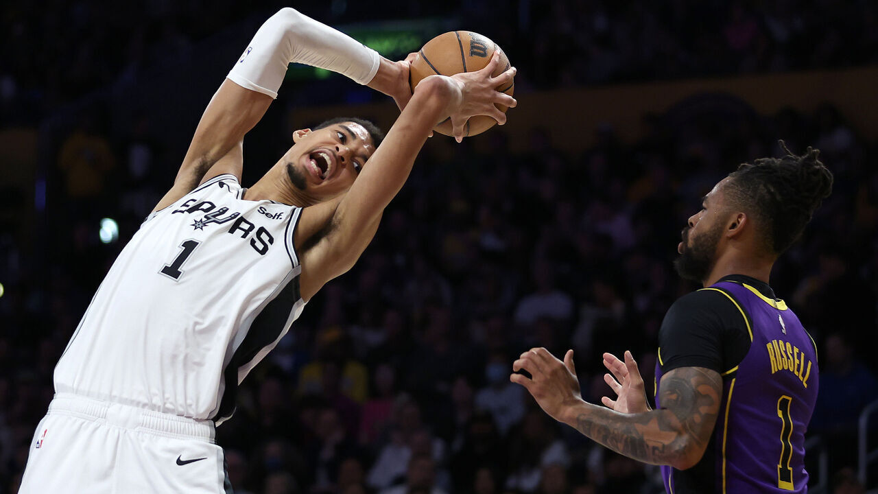 LOS ANGELES, CALIFORNIA - FEBRUARY 23: Victor Wembanyama #1 of the San Antonio Spurs rebounds against D'Angelo Russell #1 of the Los Angeles Lakers during the first half of a game at Crypto.com Arena on February 23, 2024 in Los Angeles, California.