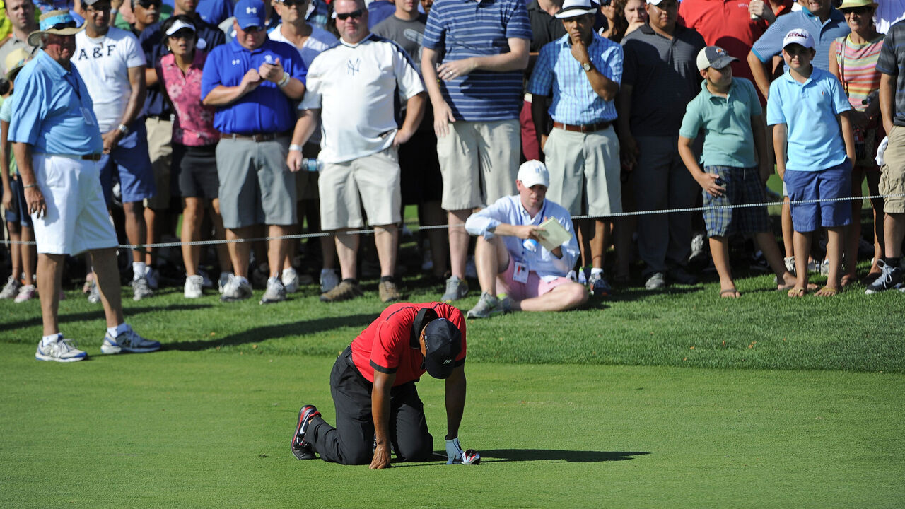 JERSEY CITY, NJ - AUGUST 25: Tiger Woods falls to the ground in pain after hitting his second shot on the 13th hole during the final round of The Barclays at Liberty National Golf Club on August 25, 2013 in Jersey City, New Jersey.