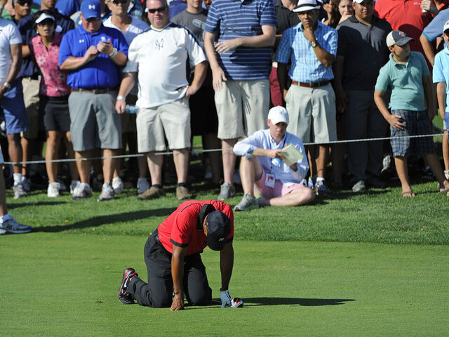 JERSEY CITY, NJ - AUGUST 25: Tiger Woods falls to the ground in pain after hitting his second shot on the 13th hole during the final round of The Barclays at Liberty National Golf Club on August 25, 2013 in Jersey City, New Jersey.