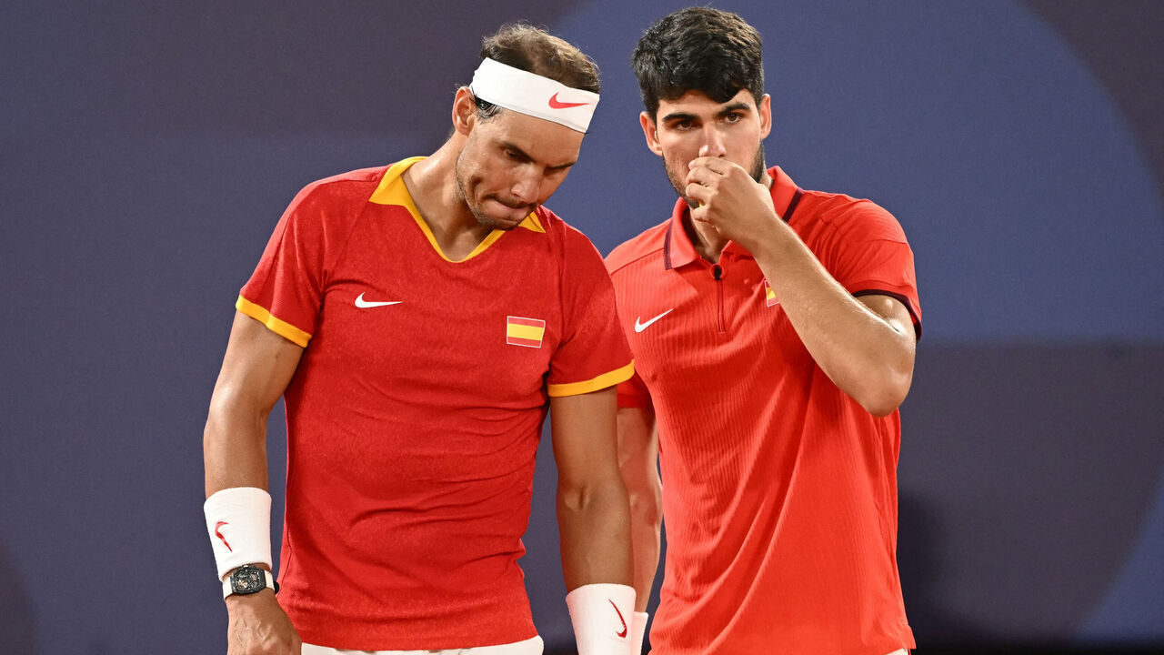 Spain's Rafael Nadal (L) and Spain's Carlos Alcaraz (R) speak while playing US' Austin Krajicek and US' Rajeev Ram during their men's doubles quarter-final tennis match on Court Philippe-Chatrier at the Roland-Garros Stadium during the Paris 2024 Olympic Games, in Paris on July 31, 2024.