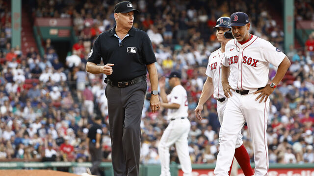 BOSTON, MA - JULY 31: Manager Alex Cora #13 of the Boston Red Sox, right, talks with umpire Cory Blaser #89 after Tyler O'Neill #17, second from right, was called out for interference on a pop up in the infield during the seventh inning at Fenway Park on July 31, 2024 in Boston, Massachusetts.