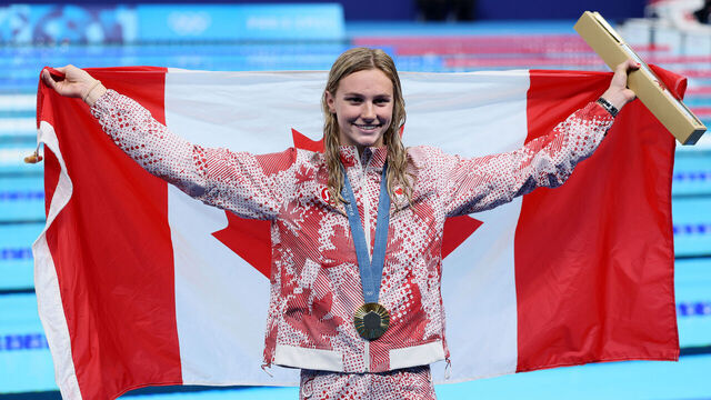 NANTERRE, FRANCE - AUGUST 01: Gold Medalist Summer McIntosh of Team Canada poses with the national flag of Canada following the Swimming medal ceremony after the Women's 200m Butterfly Final on day six of the Olympic Games Paris 2024 at Paris La Defense Arena on August 01, 2024 in Nanterre, France.