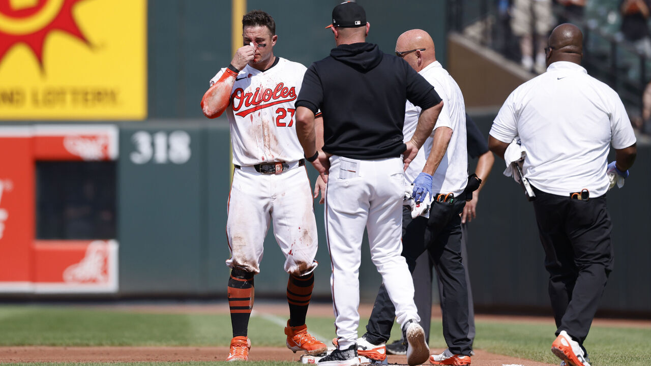 BALTIMORE, MD - JULY 29: Baltimore Orioles catcher James McCann (27) tries to stop bleeding after being hit in the face with a pitch in the first inning during an MLB game against the Toronto Blue Jays on July 29, 2024 at Oriole Park at Camden Yards in Baltimore, Maryland.