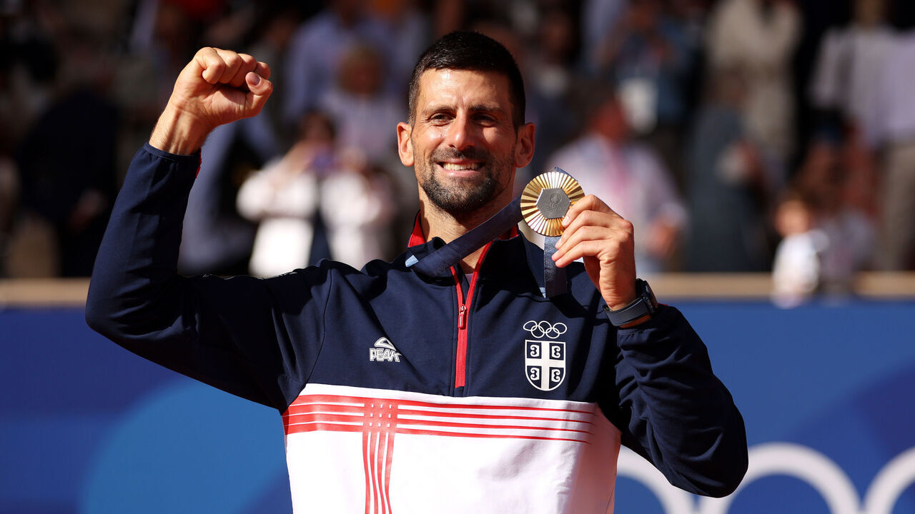 PARIS, FRANCE - AUGUST 04: Gold medallist Novak Djokovic of Team Serbia celebrates on the podium during the Tennis Men's Singles medal ceremony after the Tennis Men's Singles Gold medal match on day nine of the Olympic Games Paris 2024 at Roland Garros on August 04, 2024 in Paris, France.