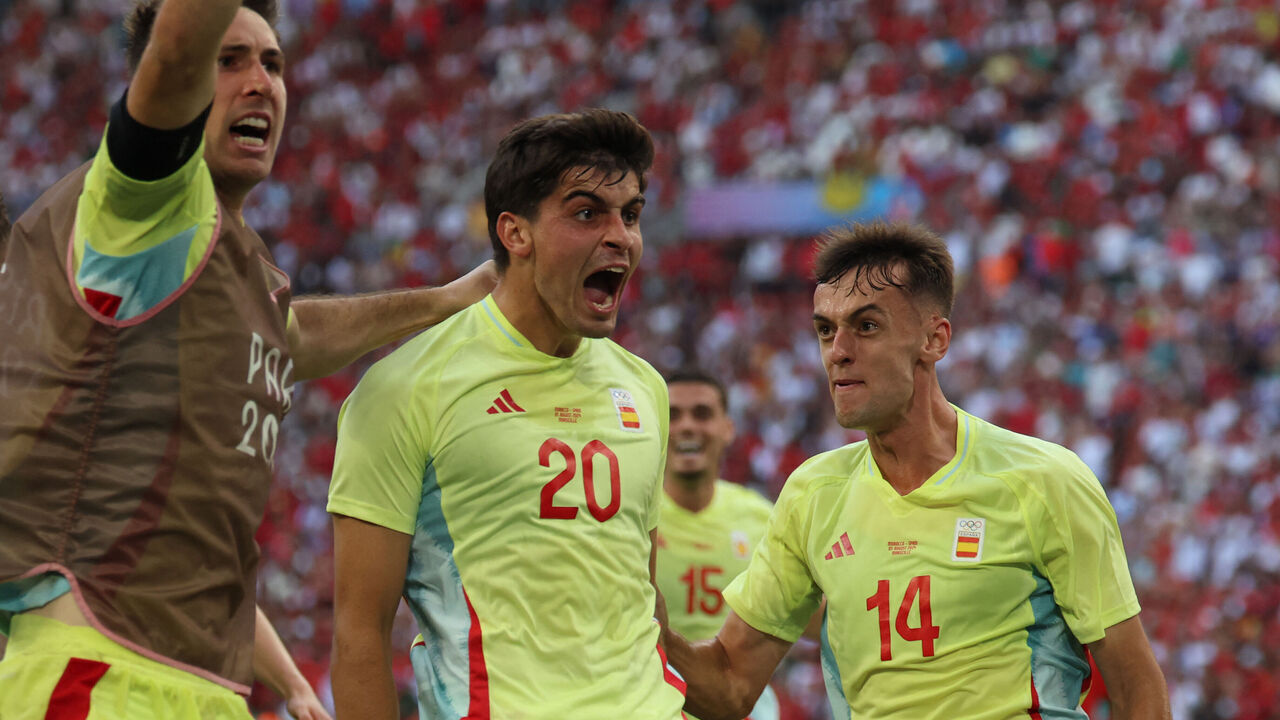 Spain's defender #20 Junlu Sanchez (C) celebrates with Spain's defender #03 Juan Miranda (L) and Spain's midfielder #14 Aimar Oroz after scoring his team's second goal during the men's semi-final football match between Morocco and Spain of the Paris 2024 Olympic Games at the Marseille Stadium in Marseille on August 5, 2024.