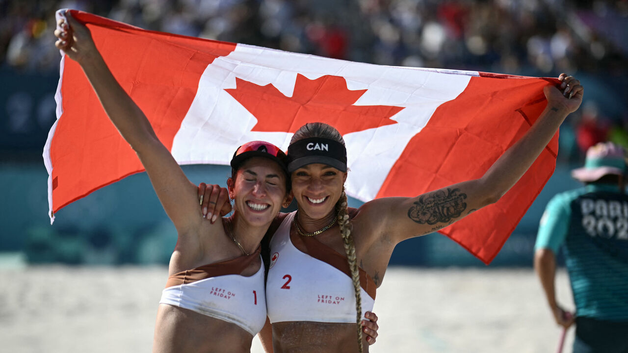 Canada's #02 Brandie Wilkerson and Canada's #01 Melissa Humana-Paredes celebrate their victory in the women's semi-final beach volleyball match between Switzerland and Canada during the Paris 2024 Olympic Games at the Eiffel Tower Stadium in Paris on August 8, 2024.