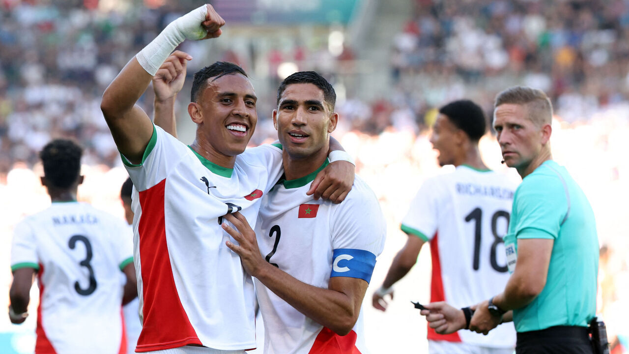 (From L) Morocco's forward #09 Soufiane Rahimi celebrates scoring the opening goal with Morocco's defender #02 Achraf Hakimi in the men's bronze medal football match between Egypt and Morocco during the Paris 2024 Olympic Games at the La Beaujoire Stadium in Nantes on August 8, 2024.
