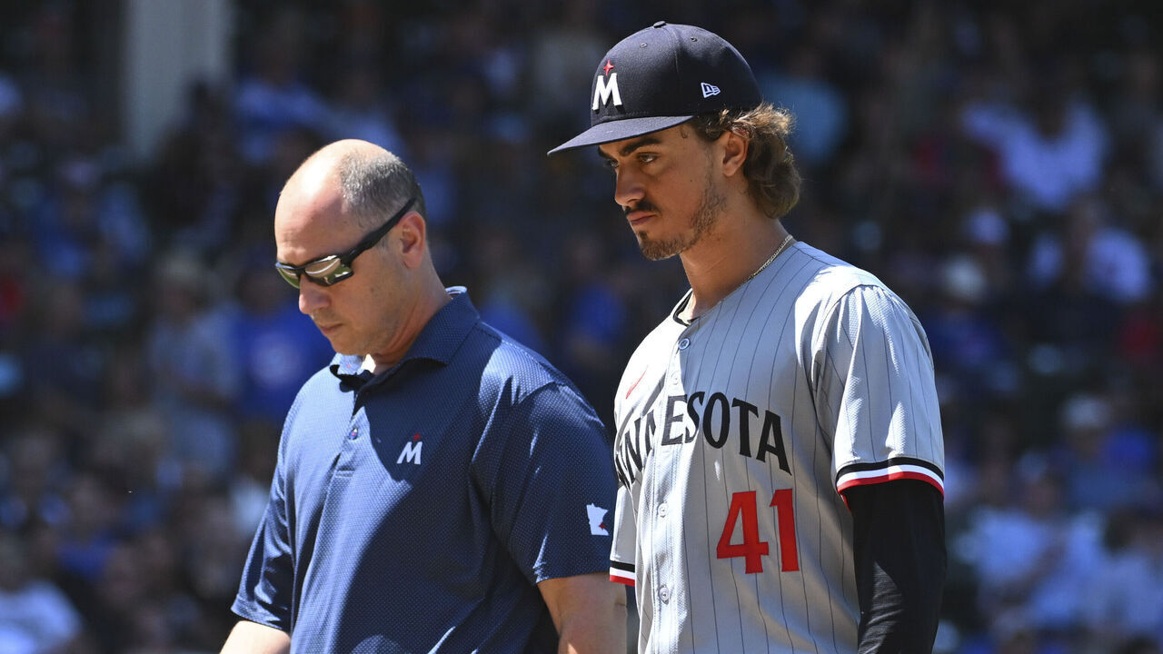 CHICAGO, ILLINOIS - AUGUST 07: Joe Ryan #41 of the Minnesota Twins leaves the game with an athletic trainer during the third inning against the Chicago Cubs at Wrigley Field on August 07, 2024 in Chicago, Illinois.