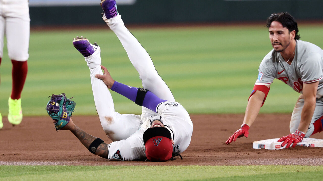 PHOENIX, ARIZONA - AUGUST 10: Ketel Marte #4 of the Arizona Diamondbacks reacts after an apparent injury after tagging Garrett Stubbs #21 of the Philadelphia Phillies during the fourth inning at Chase Field on August 10, 2024 in Phoenix, Arizona.
