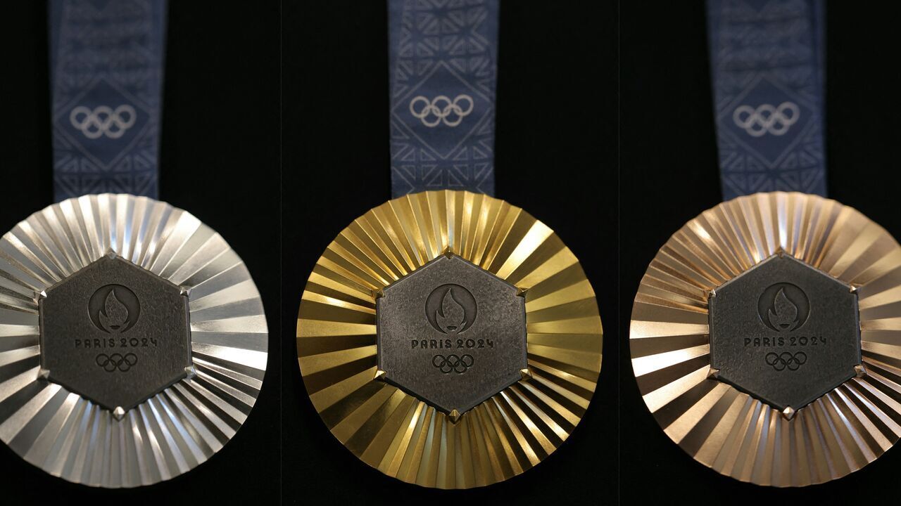 (COMBO) This combination of pictures created on January 30, 2024 in Paris shows the upcoming Paris 2024 Olympics medals designed by Fench luxury jewellery house Chaumet. On the medals' head side, the engraved figures of the goddess of victory Athena, Nike, the Panathenaic stadium and the Acropolis are imposed by the International Olympic Committee (IOC) but Paris 2024 has obtained exceptional authorization to add the design of the Eiffel Tower, and use 18 grams of Eiffel Tower metal on each medal, extracted from pieces of the tower.
