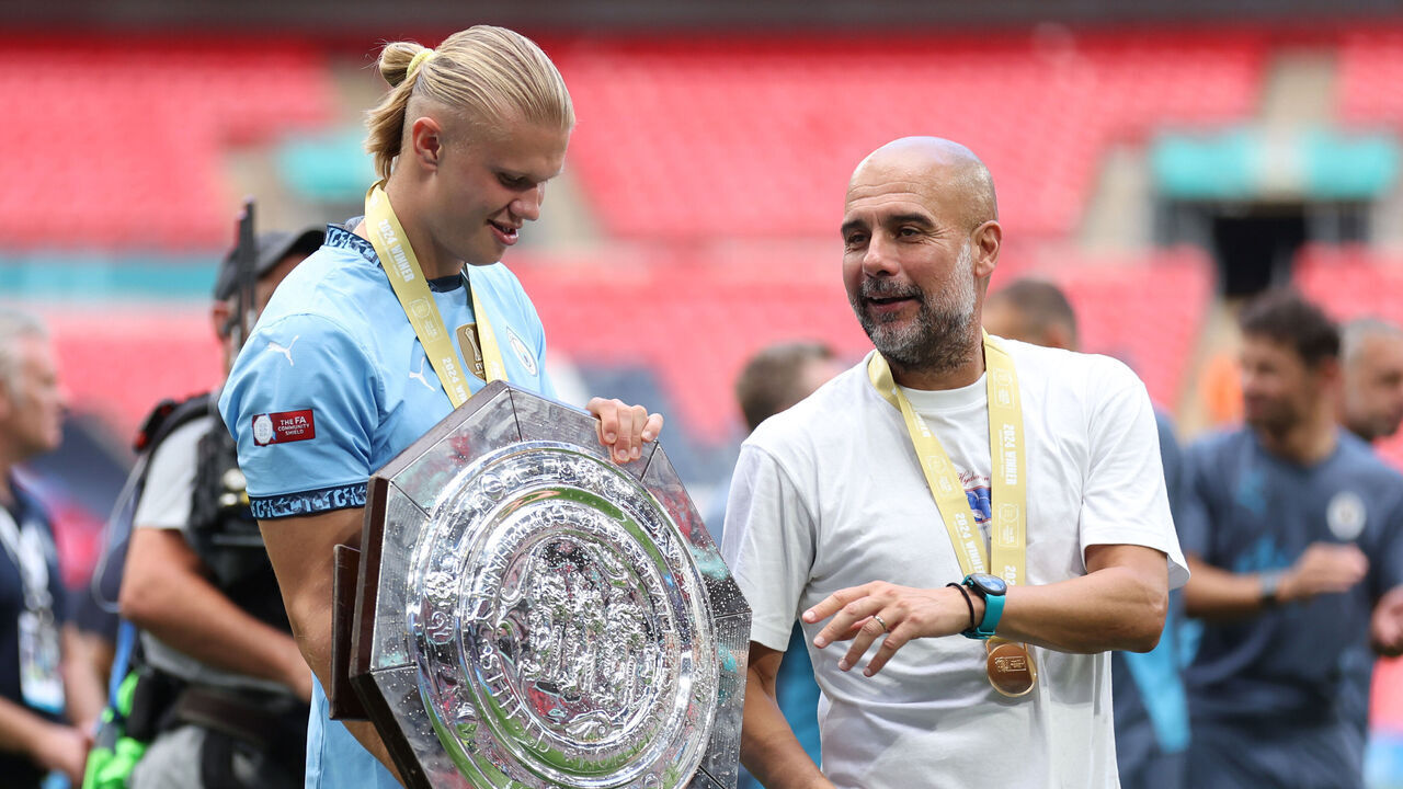 LONDON, ENGLAND - AUGUST 10: Pep Guardiola Manager / Head Coach of Manchester City and Erling Haaland of Manchester City with the trophy after the 2024 FA Community Shield match between Manchester United and Manchester City at Wembley Stadium on August 10, 2024 in London, England.