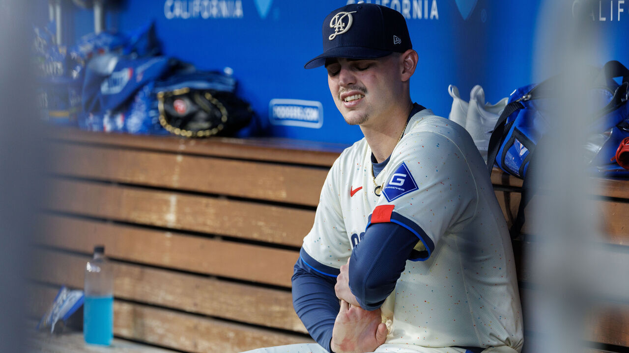 LOS ANGELES, CA - AUGUST 10, 2024: Los Angeles Dodgers starting pitcher River Ryan (77) stretches his right throwing arm in the dugout in the top of the fifth inning and was pulled from the game in the bottom of the fifth inning for a right arm injury against the Pittsburgh Pirates August 10, 2024 in Los Angeles, California. (Gina Ferazzi / Los Angeles Times via Getty Images)