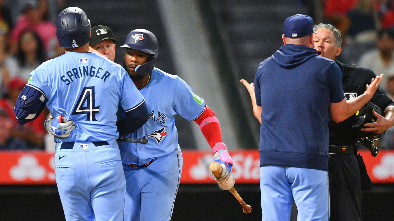 ANAHEIM, CA - AUGUST 13: Toronto Blue Jays first baseman Vladimir Guerrero Jr. (27) holds back Toronto Blue Jays right fielder George Springer (4) after he was ejected from the game as manager John Schneider argues with home plate umpire Manny Gonzalez during the MLB game between the Toronto Blue Jays and the Los Angeles Angels of Anaheim on August 13, 2024 at Angel Stadium of Anaheim in Anaheim, CA.