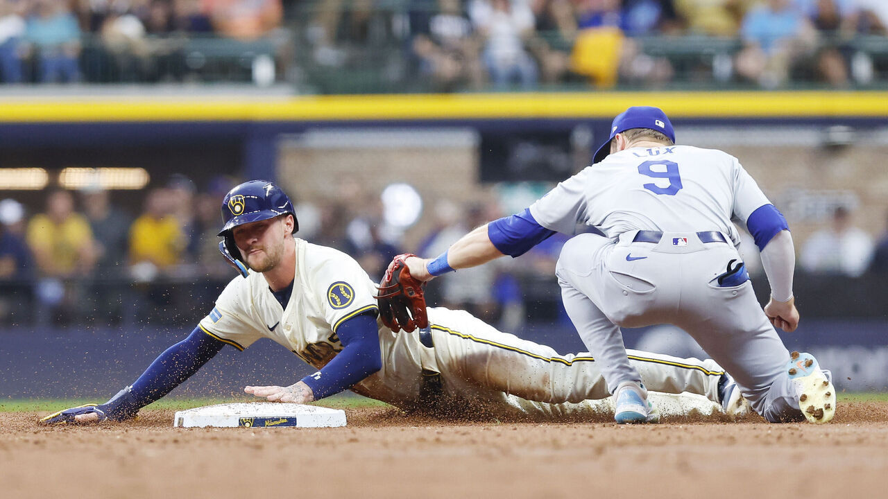 MILWAUKEE, WI - AUGUST 14: Milwaukee Brewers second base Brice Turang (2) slides in ahead of a tag by Los Angeles Dodgers second base Gavin Lux (9) during a game between the Milwaukee Brewers and the Lots Angeles Dodgers at American Family Field on August 14, 2024 in Milwaukee, WI.