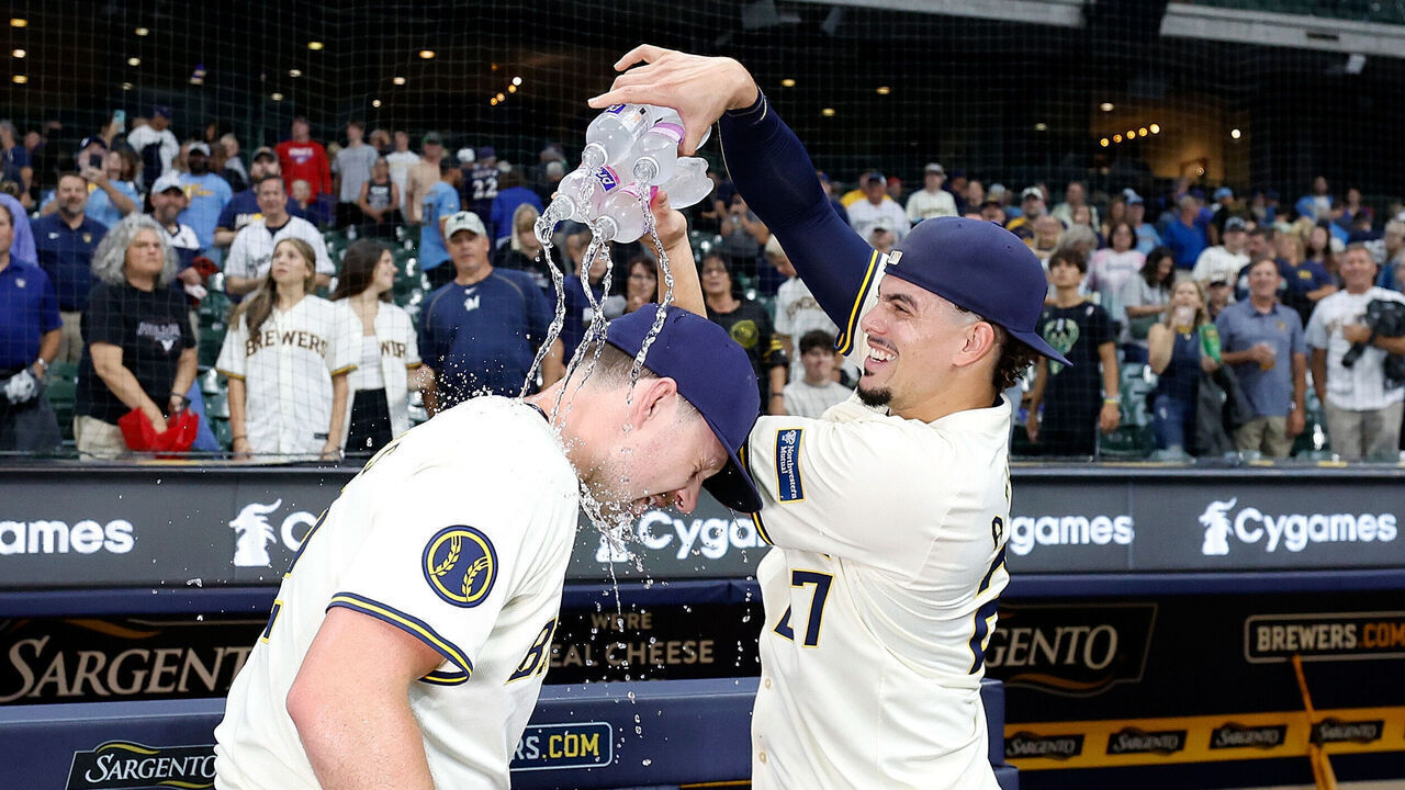 MILWAUKEE, WISCONSIN - AUGUST 15: Willy Adames #27 dumps water over Rhys Hoskins #12 of the Milwaukee Brewers after a win over the Los Angeles Dodgers at American Family Field on August 15, 2024 in Milwaukee, Wisconsin.