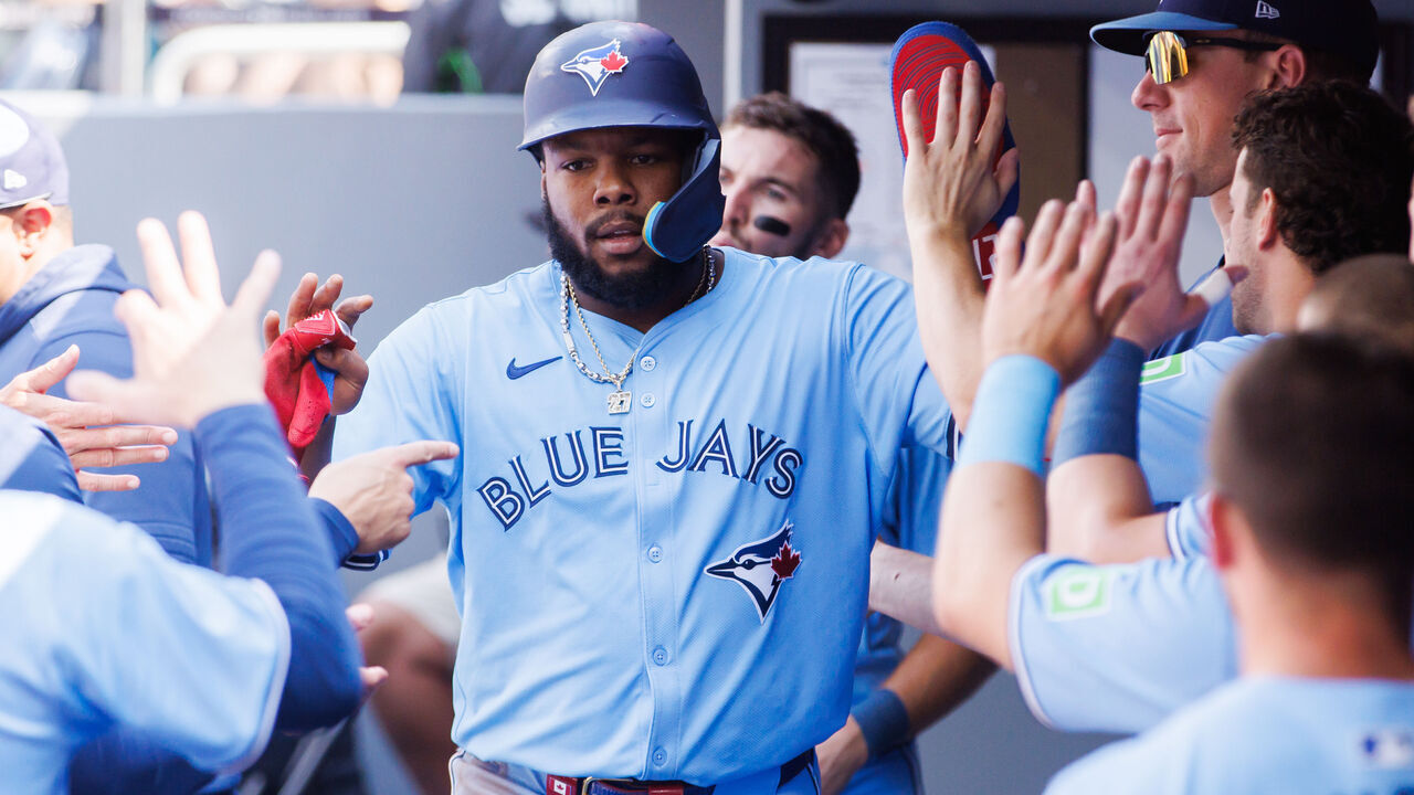 TORONTO, CANADA - AUGUST 24: Vladimir Guerrero Jr. #27 of the Toronto Blue Jays celebrates in the dugout after scoring on a double by Joey Loperfido #9 in the first inning of their MLB game against the Los Angeles Angels at Rogers Centre on August 24, 2024 in Toronto, Ontario, Canada.