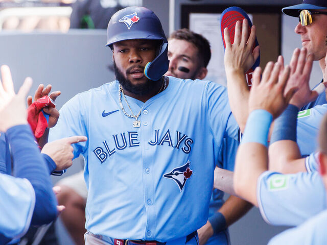 TORONTO, CANADA - AUGUST 24: Vladimir Guerrero Jr. #27 of the Toronto Blue Jays celebrates in the dugout after scoring on a double by Joey Loperfido #9 in the first inning of their MLB game against the Los Angeles Angels at Rogers Centre on August 24, 2024 in Toronto, Ontario, Canada.