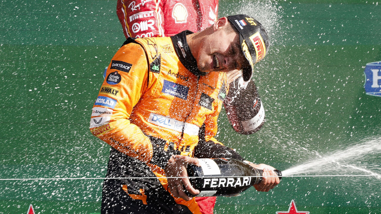 First-placed McLaren's British driver Lando Norris celebrates with third-placed Ferrari's Monegasque driver Charles Leclerc during the podium ceremony after the Formula One Dutch Grand Prix at The Circuit Zandvoort, western Netherlands, on August 25, 2024.