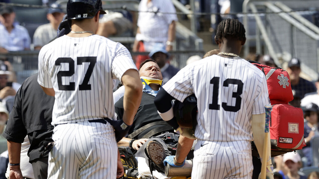 NEW YORK, NEW YORK - AUGUST 25: Giancarlo Stanton #27 and Jazz Chisholm Jr. #13 of the New York Yankees looks on as home plate umpire Nick Mahrley is tended too after he was hit by Stanton's broken bat during the fifth inning against the Colorado Rockies at Yankee Stadium on August 25, 2024 in New York City.