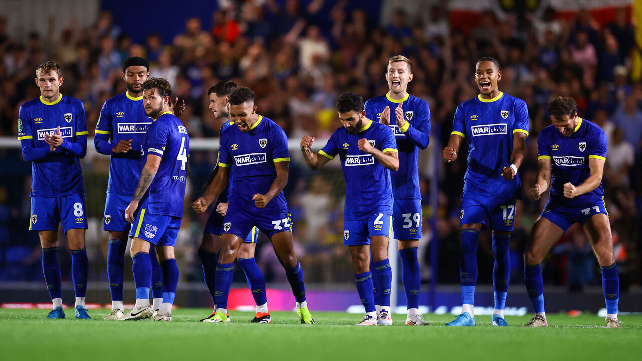 WIMBLEDON, ENGLAND - AUGUST 28: The Wimbledon squad celebrate during the penalty shoot out during the Carabao Cup Second Round match between AFC Wimbledon and Ipswich Town at The Cherry Red Records Stadium on August 28, 2024 in Wimbledon, England.