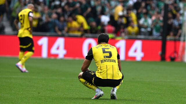 31 August 2024, Bremen: Soccer: Bundesliga, Werder Bremen - Borussia Dortmund, Matchday 2, wohninvest Weserstadion. Dortmund's Ramy Bensebaini crouches on the ground at the end of the match. Werder Bremen and Dortmund draw 0:0. Photo: Carmen Jaspersen/dpa - IMPORTANT NOTE: In accordance with the regulations of the DFL German Football League and the DFB German Football Association, it is prohibited to utilize or have utilized photographs taken in the stadium and/or of the match in the form of sequential images and/or video-like photo series.