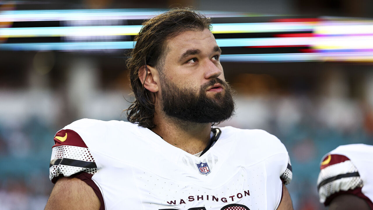 MIAMI GARDENS, FL - AUGUST 17: Sam Cosmi #76 of the Washington Commanders stands on the sidelines during the national anthem prior to an NFL preseason football game against the Miami Dolphins at Hard Rock Stadium on August 17, 2024 in Miami Gardens, FL.