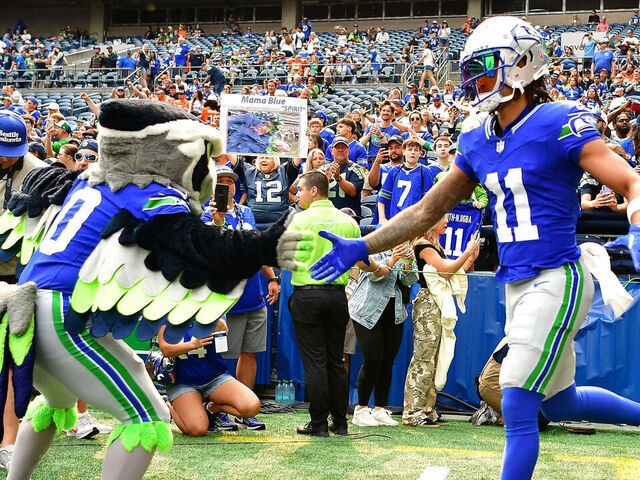 SEATTLE, WASHINGTON - SEPTEMBER 08: Jaxon Smith-Njigba #11 of the Seattle Seahawks shakes hands with Blitz the Seattle Seahawks mascot prior to a game against the Denver Broncos at Lumen Field on September 08, 2024 in Seattle, Washington.