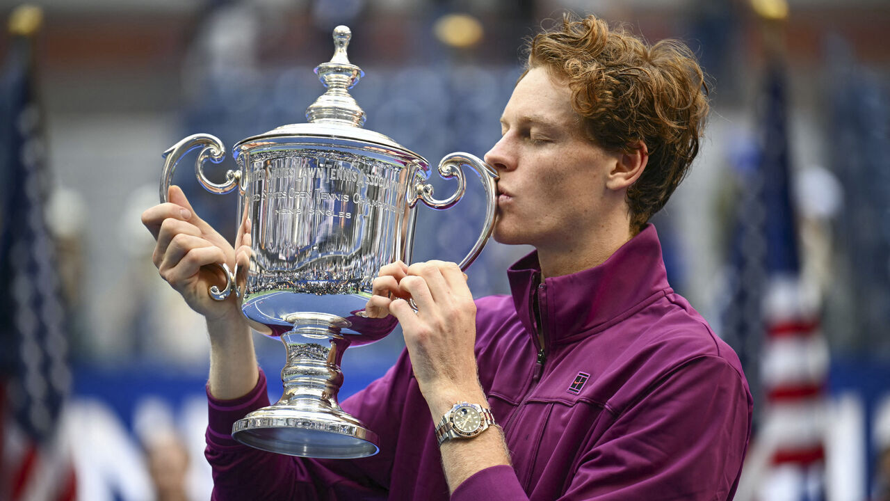 Italy's Jannik Sinner kisses the trophy after winning his men's final match against USA's Taylor Fritz on day fourteen of the US Open tennis tournament at the USTA Billie Jean King National Tennis Center in New York City, on September 8, 2024.