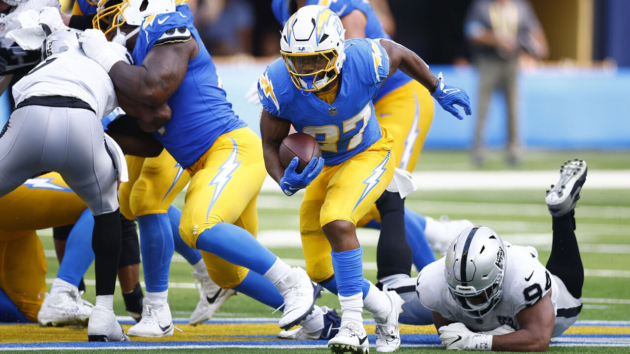 INGLEWOOD, CALIFORNIA - SEPTEMBER 08: J.K. Dobbins #27 of the Los Angeles Chargers runs past Christian Wilkins #94 of the Las Vegas Raiders during the third quarter at SoFi Stadium on September 08, 2024 in Inglewood, California.
