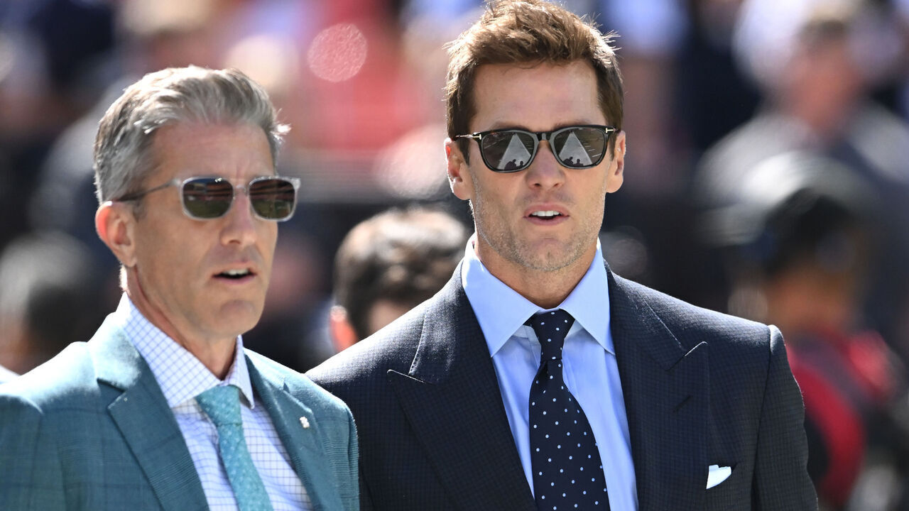 CLEVELAND, OHIO - SEPTEMBER 08: Broadcasters Kevin Burkhardt (L) and Tom Brady (R) walk along the field before the game between the Dallas Cowboys and Cleveland Browns at Cleveland Browns Stadium on September 08, 2024 in Cleveland, Ohio.